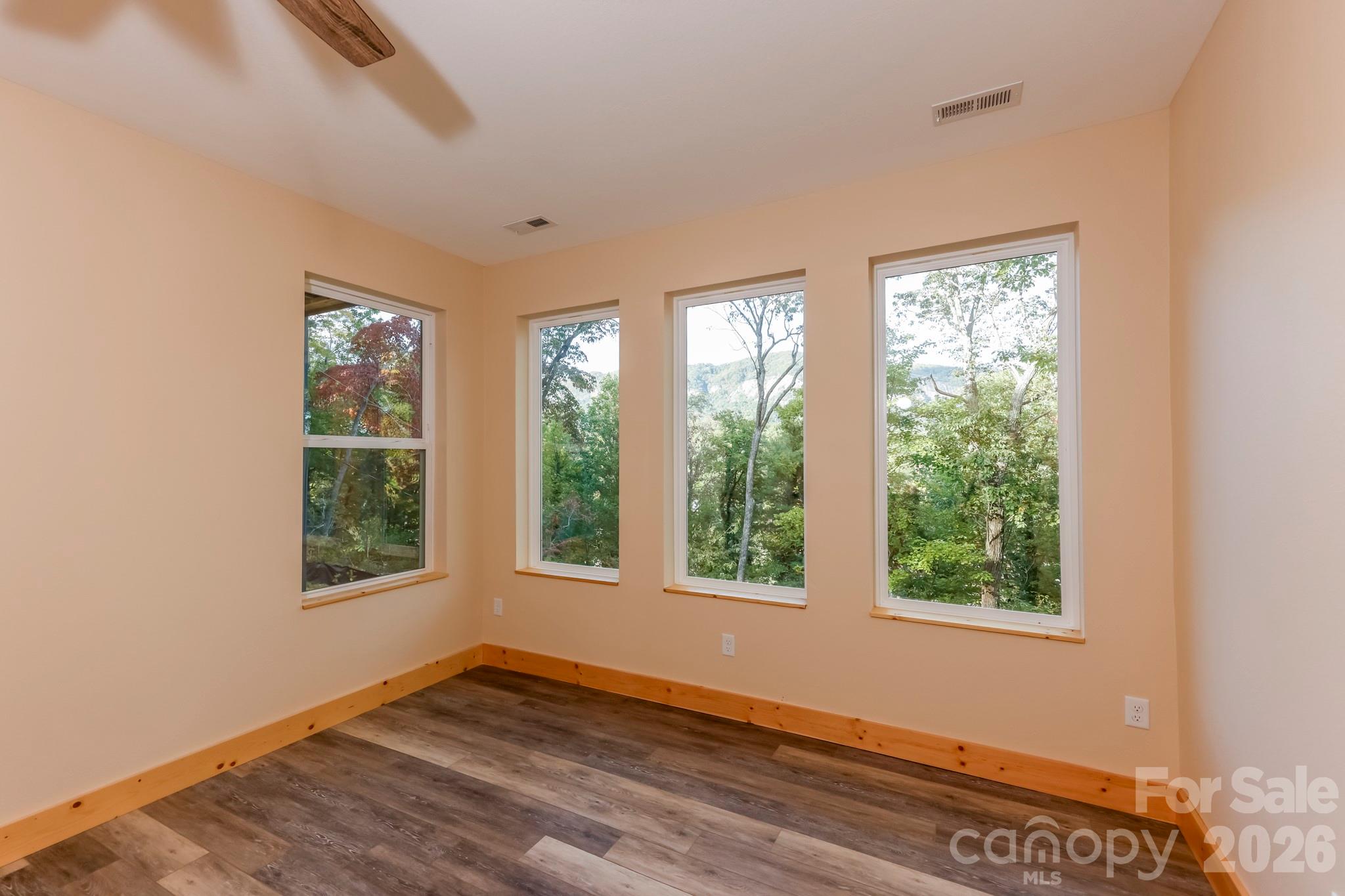 272 Seton Road Lake Lure, NC 28746 - Photo 25 of 39 a view of an empty room with wooden floor and windows