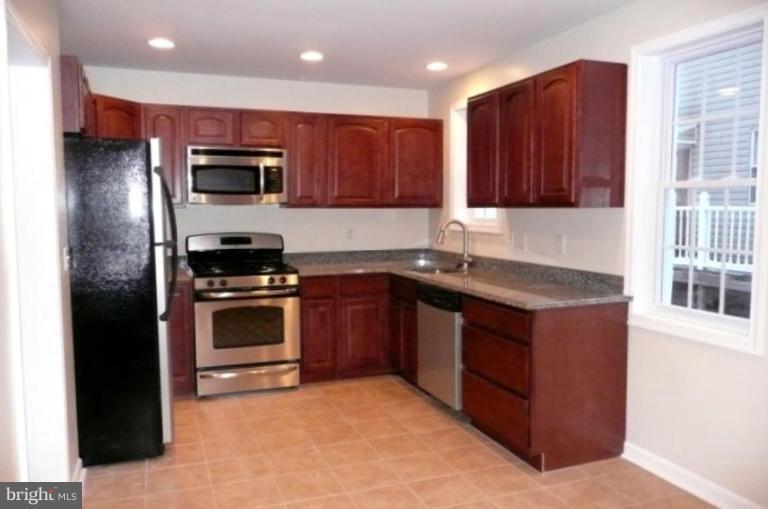 3717 Ridgecroft Road Baltimore, MD 21206 - Photo 2 of 17 a kitchen with stainless steel appliances granite countertop a stove a microwave a sink and a refrigerator