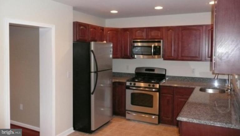 3717 Ridgecroft Road Baltimore, MD 21206 - Photo 3 of 17 a kitchen with a refrigerator and a stove top oven