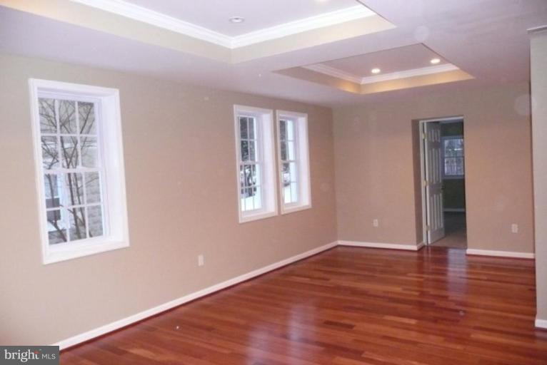 3717 Ridgecroft Road Baltimore, MD 21206 - Photo 5 of 17 a view of an empty room with wooden floor and a window