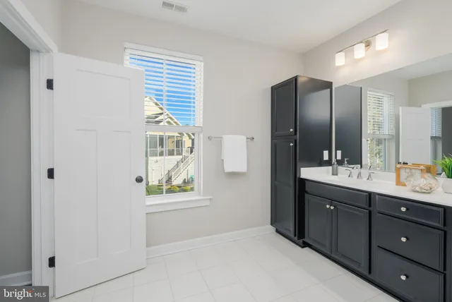 a bathroom with a double vanity sink and a window
