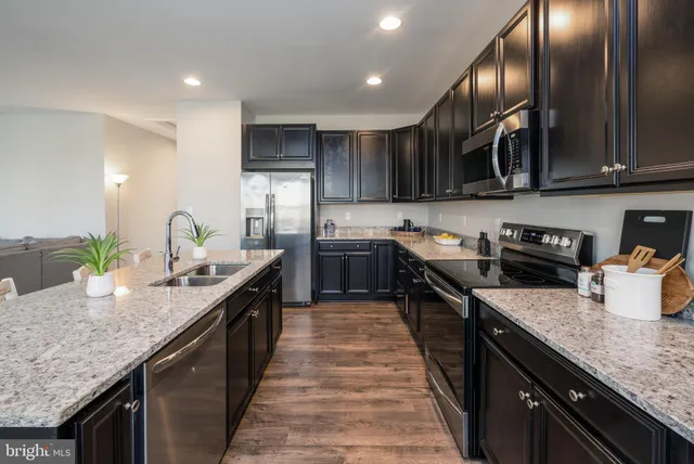 a kitchen with granite countertop stainless steel appliances and wooden cabinets
