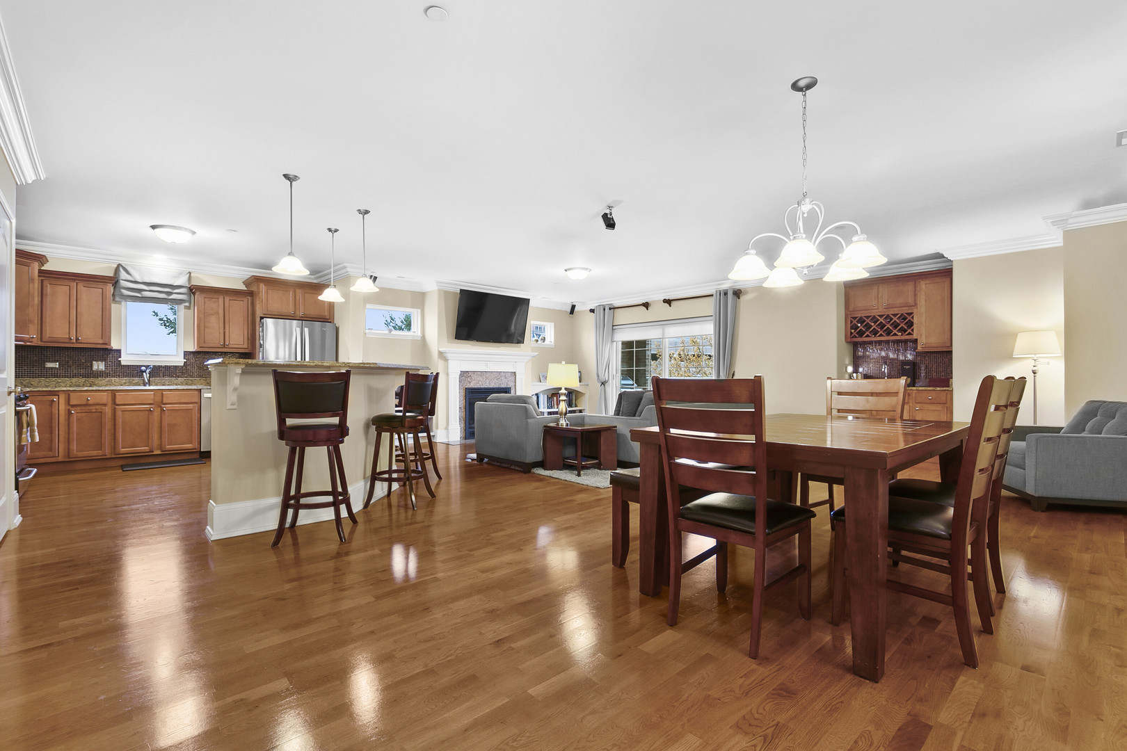 401 West Pierce Road, Unit 201 Itasca, IL 60143 - Photo 5 of 24 a view of a dining room and livingroom with furniture wooden floor a rug a flat screen tv a painting and a chandelier