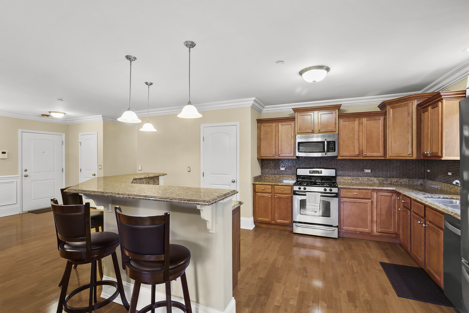 401 West Pierce Road, Unit 201 Itasca, IL 60143 - Photo 7 of 24 a kitchen with stainless steel appliances granite countertop a stove top oven a sink dishwasher a dining table and chairs with wooden floor