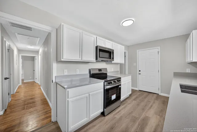 a kitchen with stainless steel appliances granite countertop a stove top oven a sink and a microwave