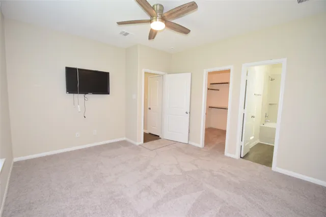 an empty room with closet and a ceiling fan