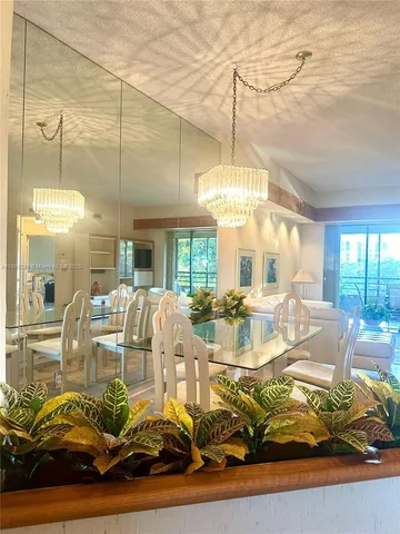 a view of a dining room with furniture a chandelier and wooden floor