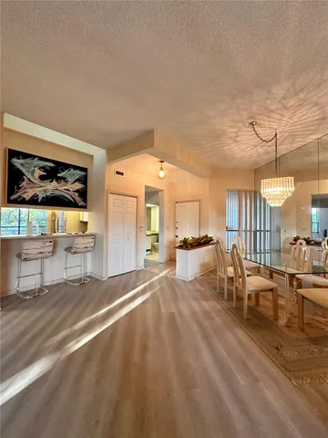 a living room with couches and kitchen view with wooden floor