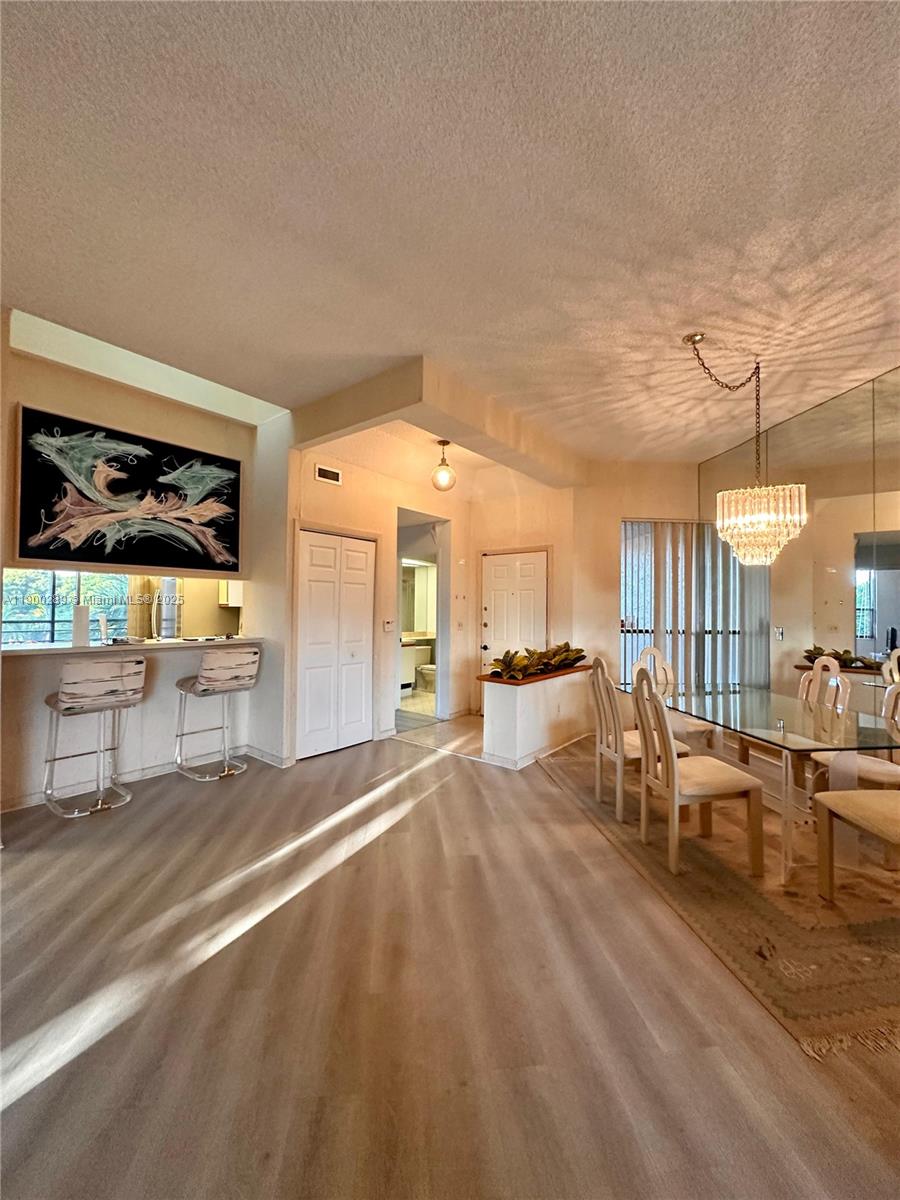 7472 La Paz Boulevard, Unit 301 Boca Raton, FL 33433 - Photo 3 of 17 a living room with couches and kitchen view with wooden floor