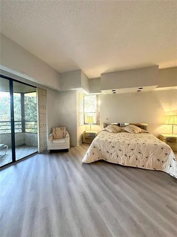 a spacious bedroom with a large bed and a large window