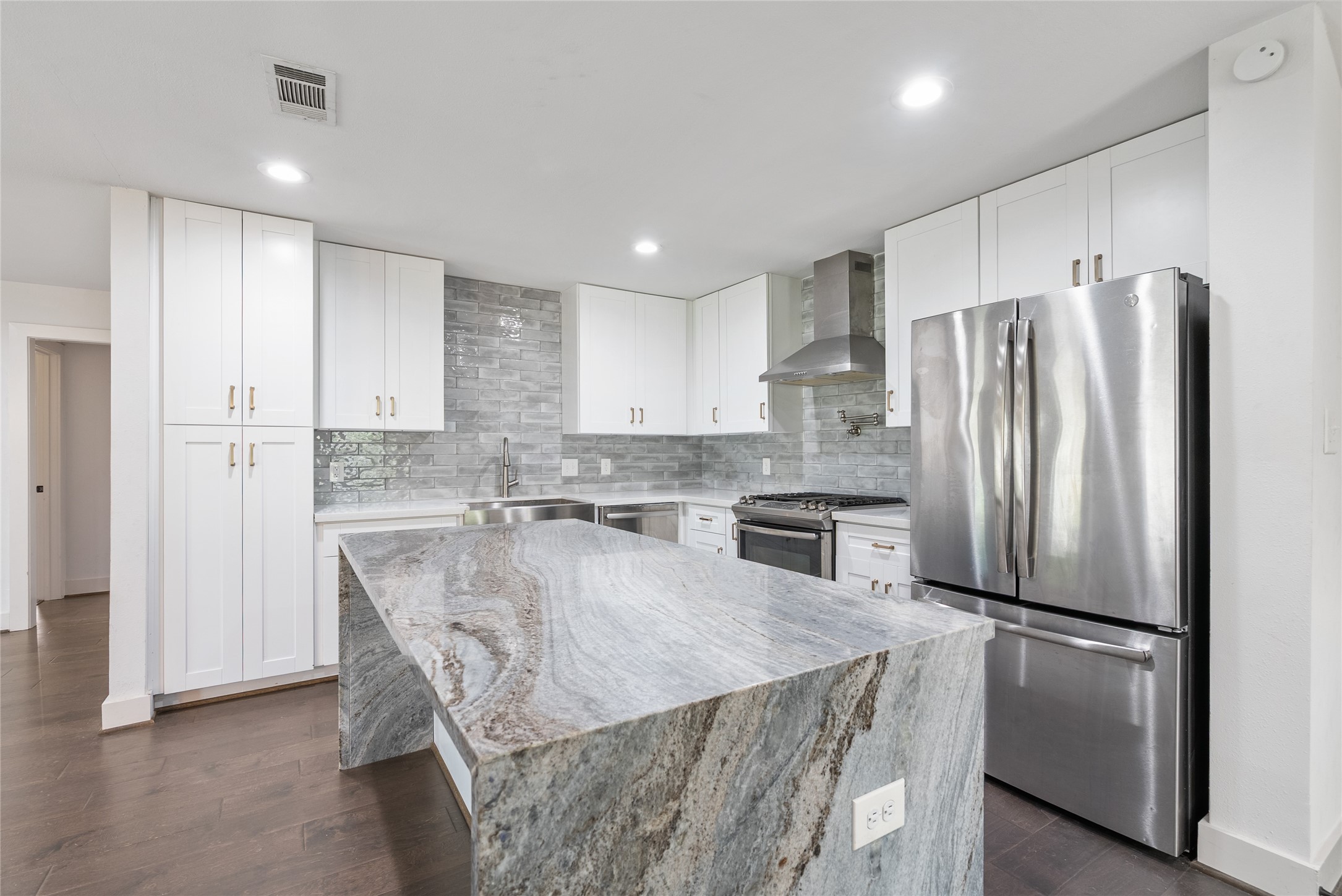 7307 Raton Street Houston, TX 77055 - Photo 12 of 23 The waterfall island is the perfect place to gather with loved ones! Bar seating is also conveniently available!