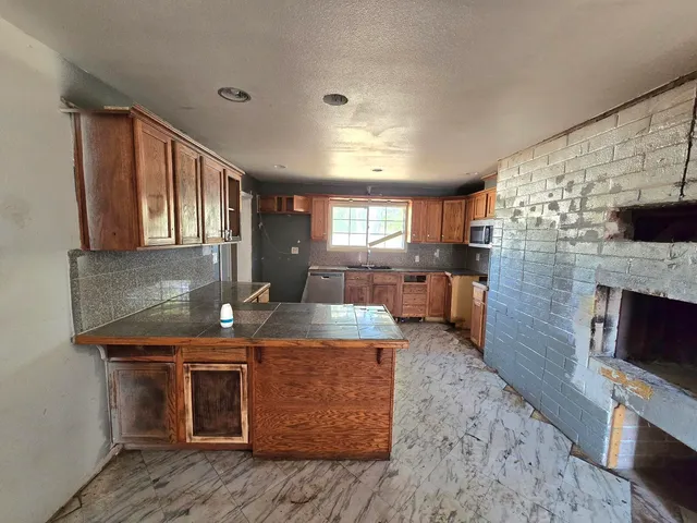 a kitchen with stainless steel appliances granite countertop a stove a sink and a microwave
