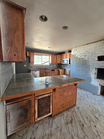 a kitchen with stainless steel appliances granite countertop a stove a sink and a microwave
