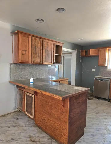 a kitchen with granite countertop a sink and a stove