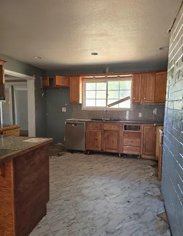 a kitchen with granite countertop a sink and a stove