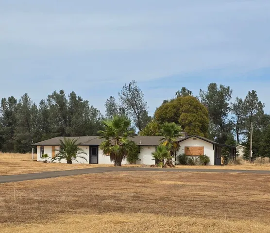 a front view of house with yard and trees around