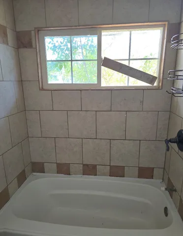 an empty room with wooden floor cabinet and windows