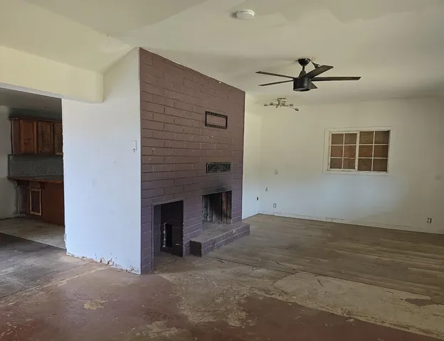 a view of a livingroom with a ceiling fan window and a ceiling fan
