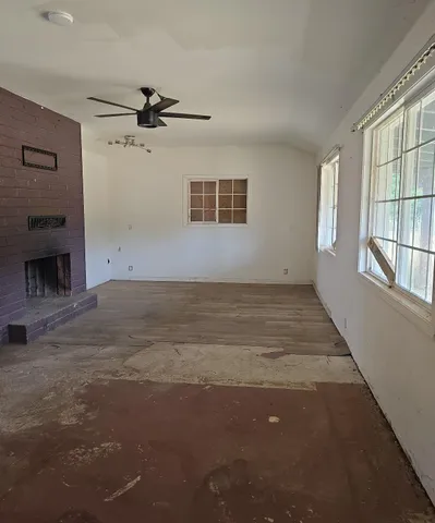an empty room with windows and fireplace