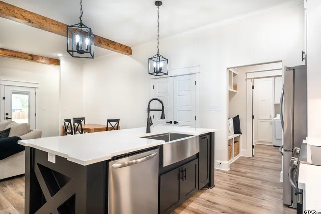a kitchen with a sink a counter space and wooden floor
