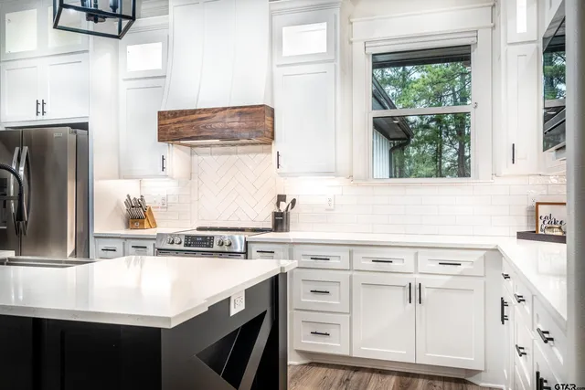 a kitchen with cabinets appliances a sink and a window