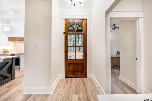 a view of a hallway view with wooden floor and a living room