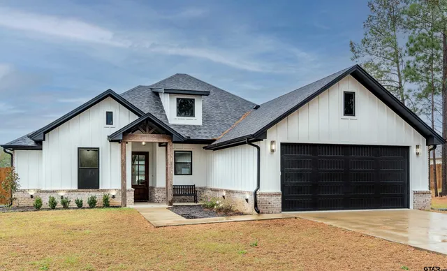 a front view of a house with a yard outdoor seating and garage
