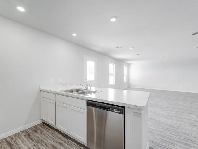a kitchen with sink and mirror