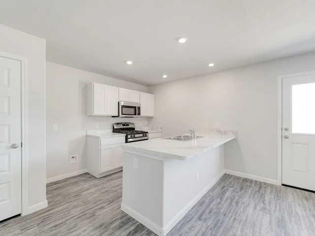 a kitchen with stainless steel appliances a sink stove and refrigerator