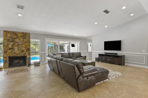 a living room with furniture a flat screen tv and a fireplace