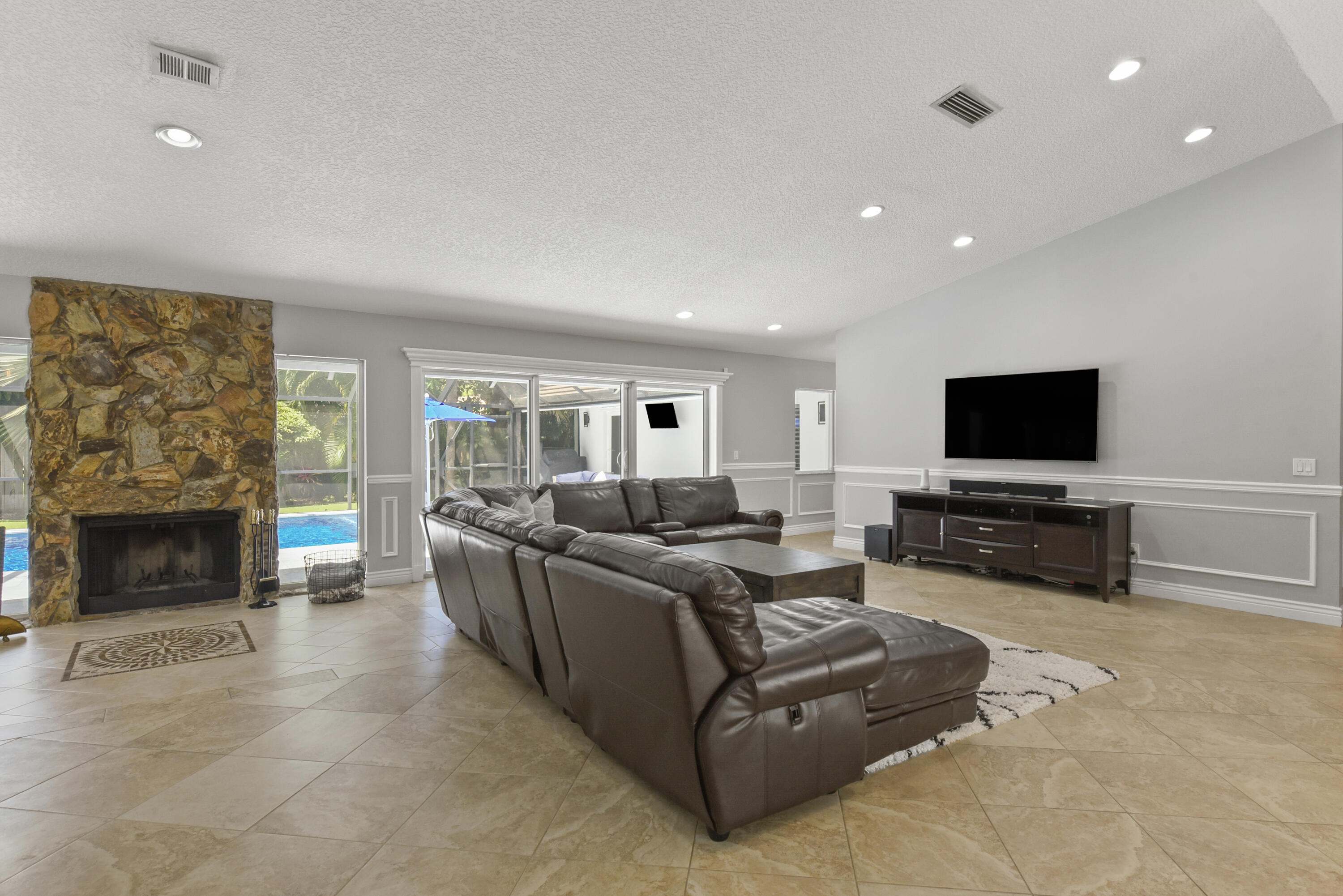 2659 Northwest 26th Circle Boca Raton, FL 33431 - Photo 12 of 34 a living room with furniture a flat screen tv and a fireplace