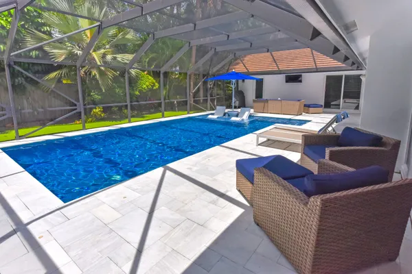 a view of a house with swimming pool and sitting area