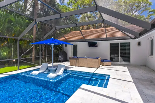 a view of a patio with table and chairs under an umbrella