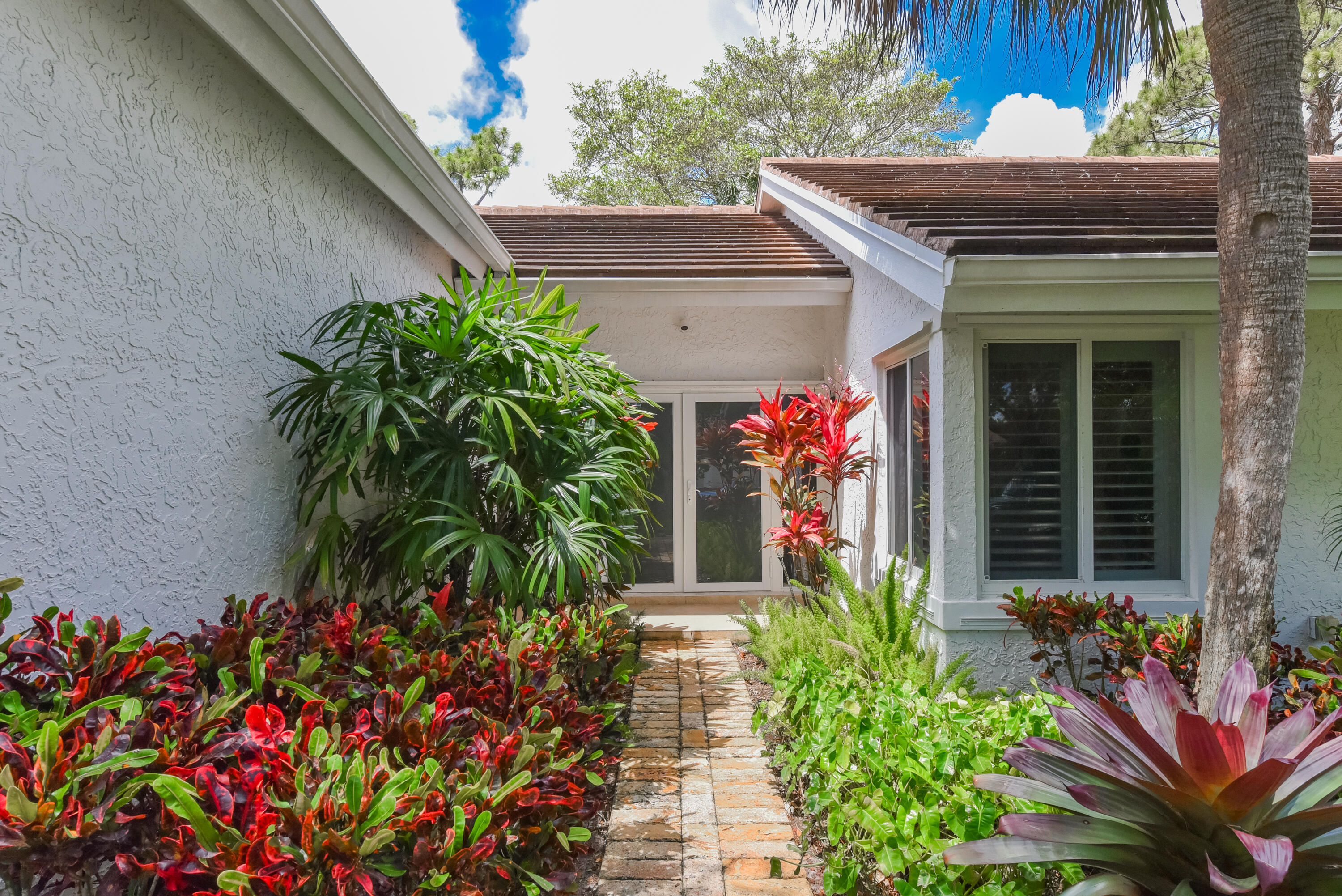 2659 Northwest 26th Circle Boca Raton, FL 33431 - Photo 3 of 34 a front view of a house with a flower garden