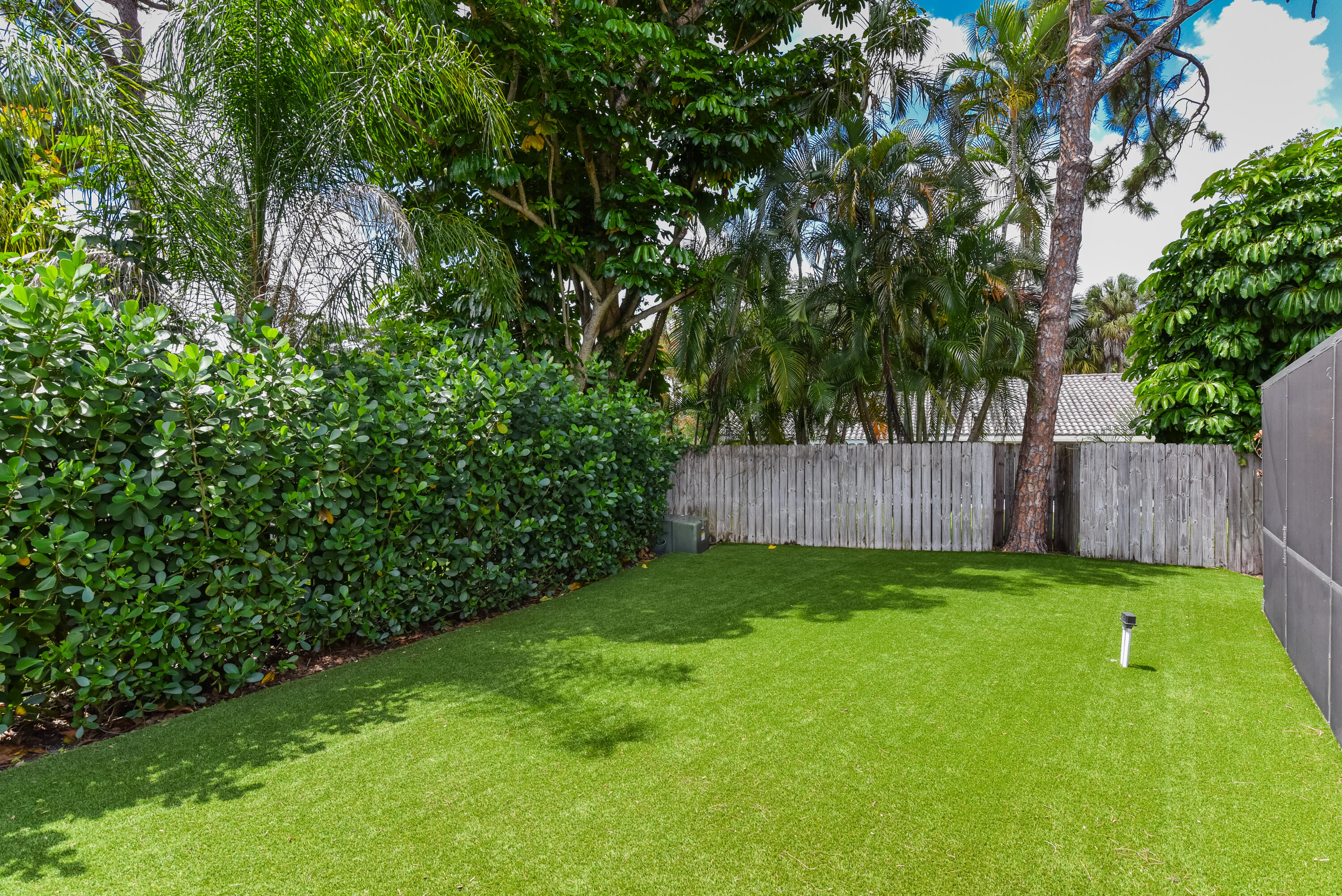 2659 Northwest 26th Circle Boca Raton, FL 33431 - Photo 32 of 34 a view of a yard with large trees and wooden fence