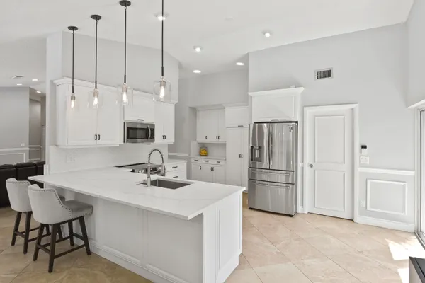 a kitchen with kitchen island a appliances a sink a center island and furniture