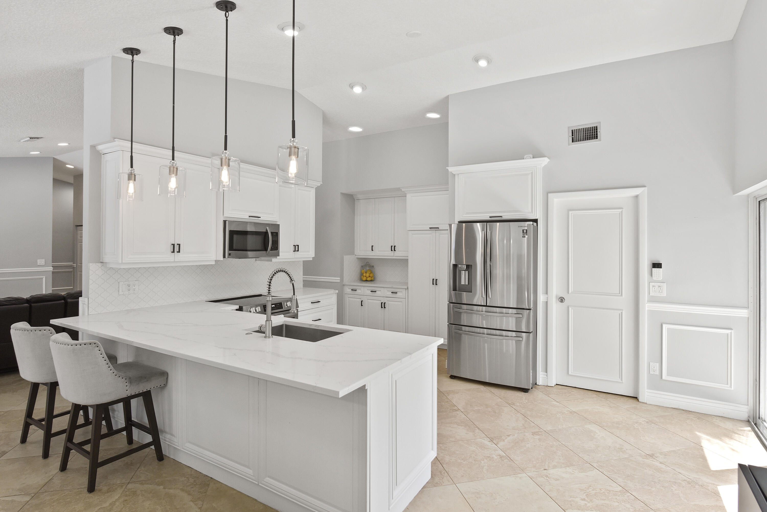 2659 Northwest 26th Circle Boca Raton, FL 33431 - Photo 5 of 34 a kitchen with kitchen island a appliances a sink a center island and furniture