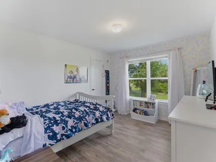 a bedroom with a bed and a large window