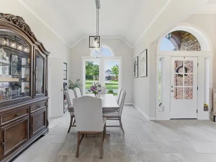 a dining room with furniture a chandelier and window