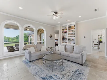 a living room with furniture potted plant and a large window