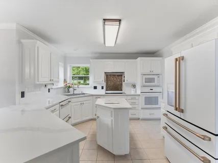 a kitchen with white cabinets and white appliances