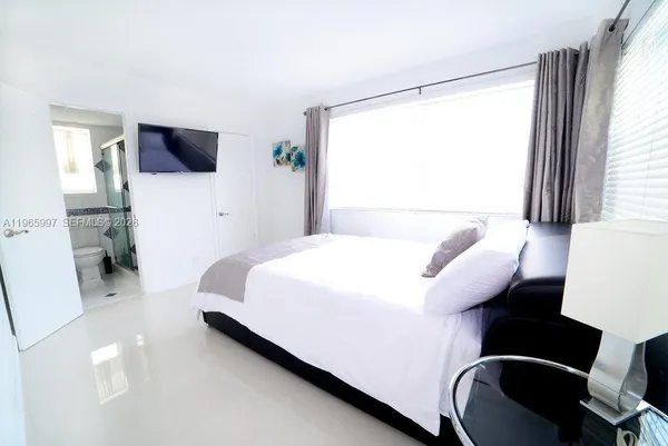 a bedroom with a bed and a flat screen tv