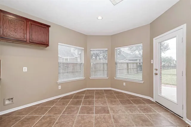 a view of an empty room with a fireplace and a window