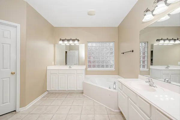 a bathroom with a sink vanity tub and a mirror