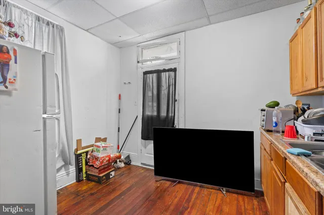 a living room with stainless steel appliances wooden floor and a window