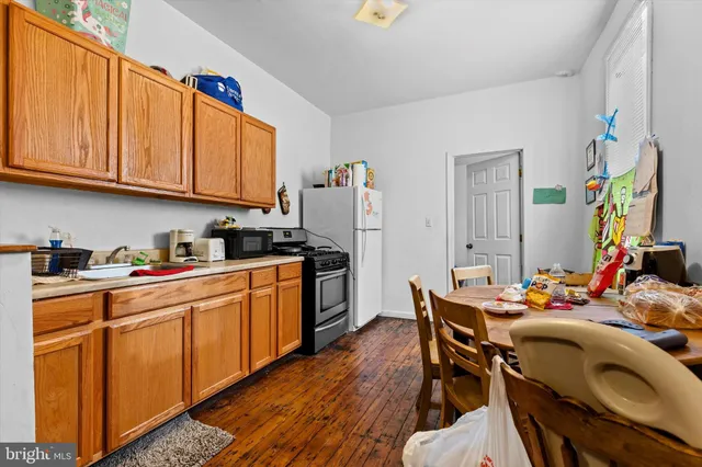 a kitchen with stainless steel appliances a stove a sink dishwasher and cabinets with wooden floor