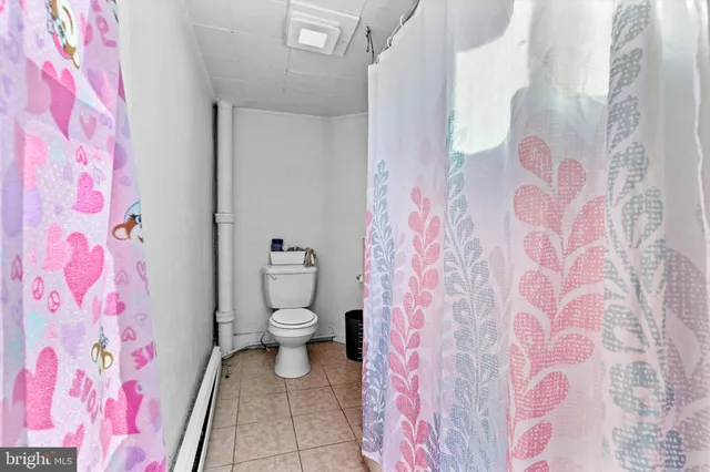 a bathroom with a toilet and a shower curtain