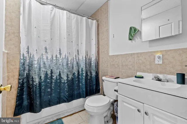 a bathroom with a toilet a sink and curtain
