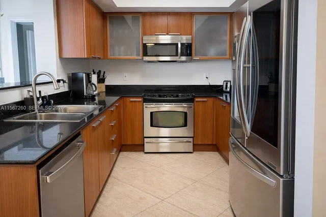 a kitchen with stainless steel appliances granite countertop a sink stove and microwave