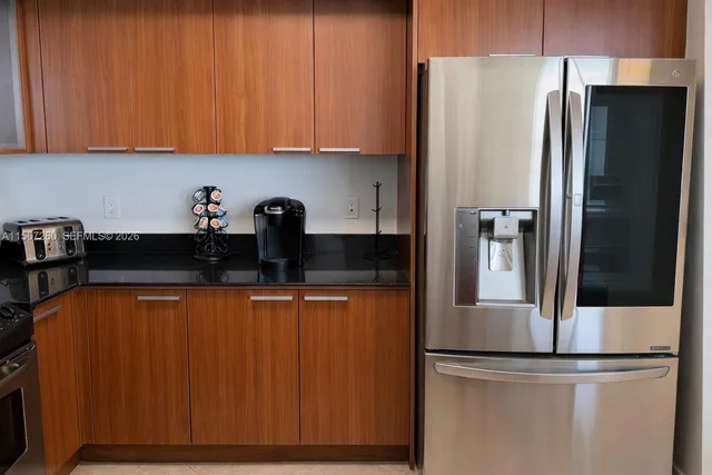 a kitchen with stainless steel appliances granite countertop a refrigerator and a sink